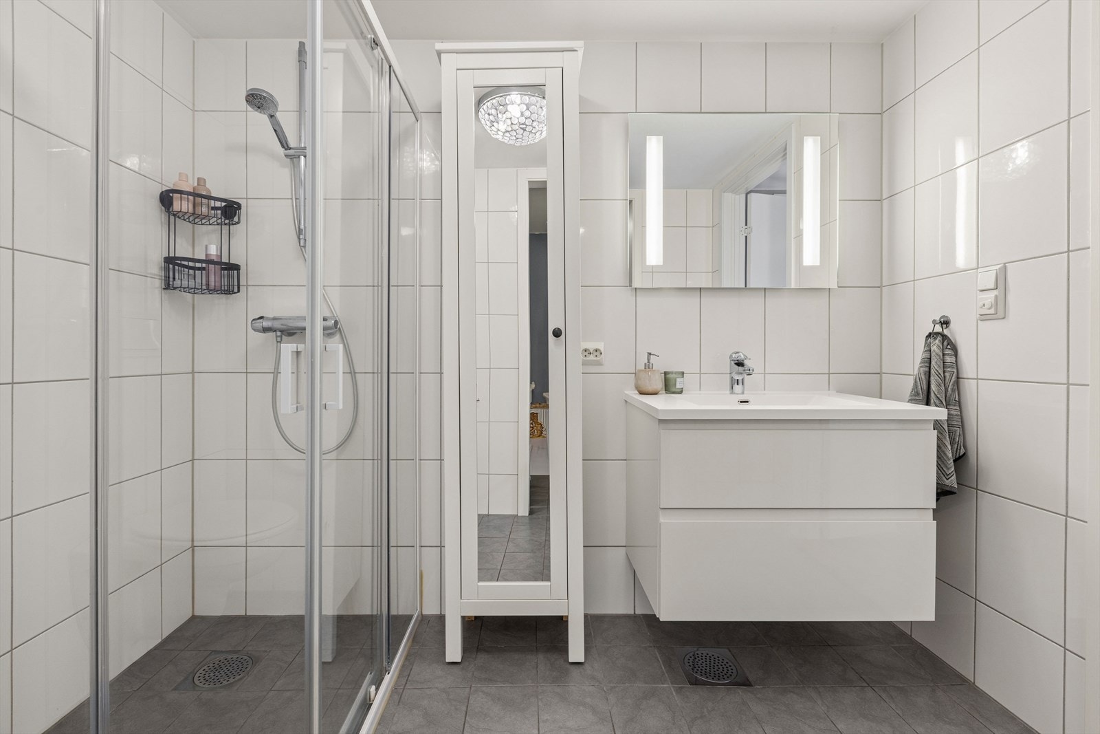 Badet er ellers utstyrt med dusjhjørne, vegghengt toalett og baderomsinnredning med god lagringsplass og nedfelt servant. Galleribilde