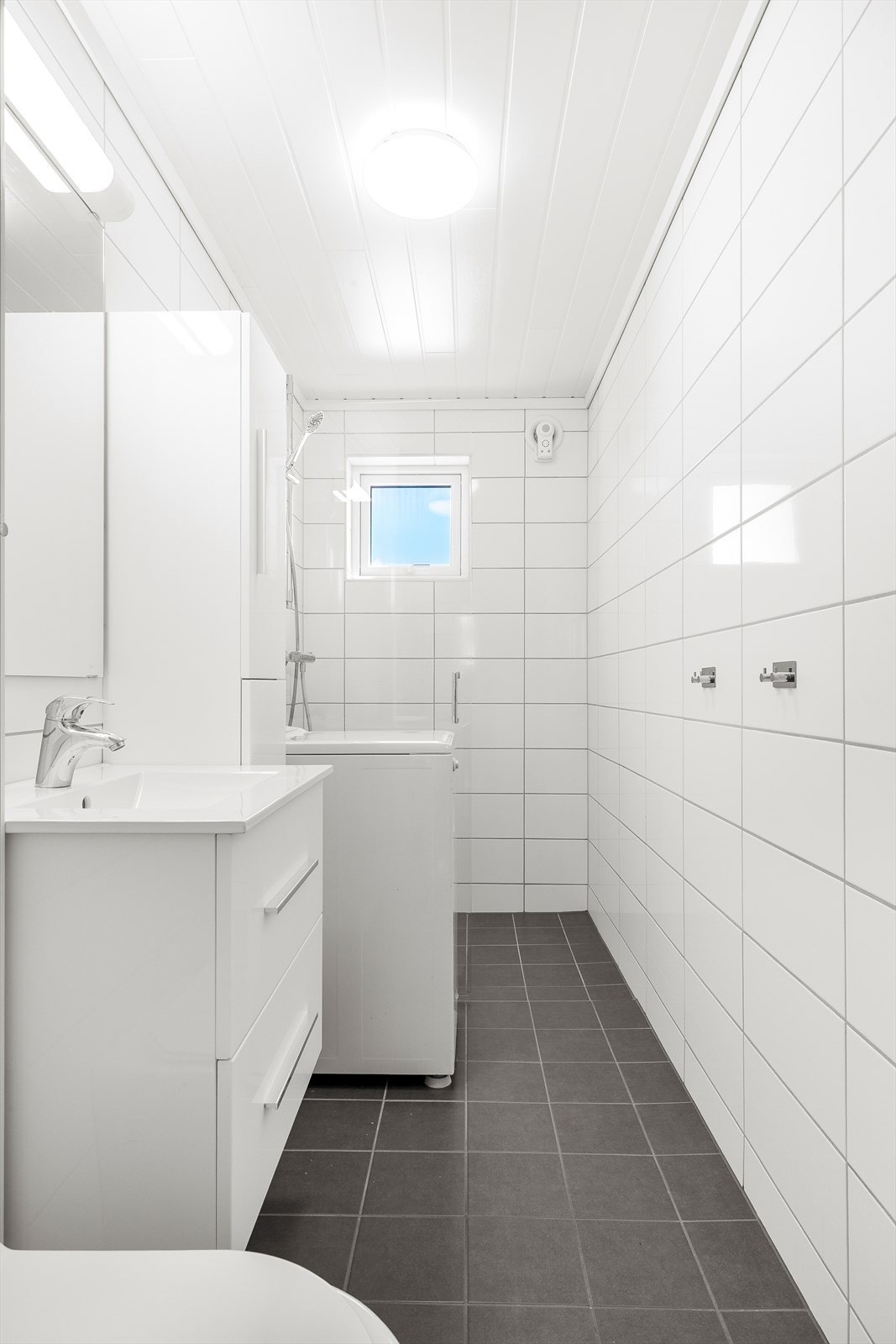Her er det vegghengt toalett, dusjhjørne og opplegg for vaskemaskin. Ferdigattest for badet foreligger fra 2022. Galleribilde