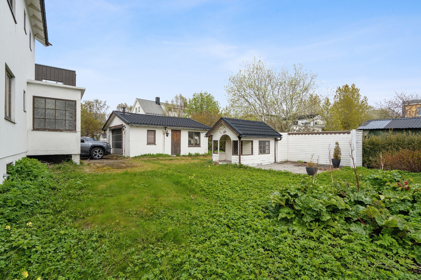 Eiendommen har en stor og fin hage med garasje og et lite lysthus. Galleribilde