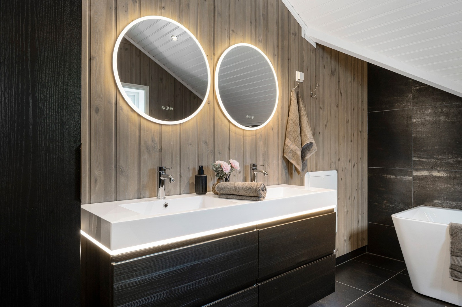 Badet er romslig og innredet med dobbel servant, dusjnisje, badekar og vegghengt wc. Galleribilde