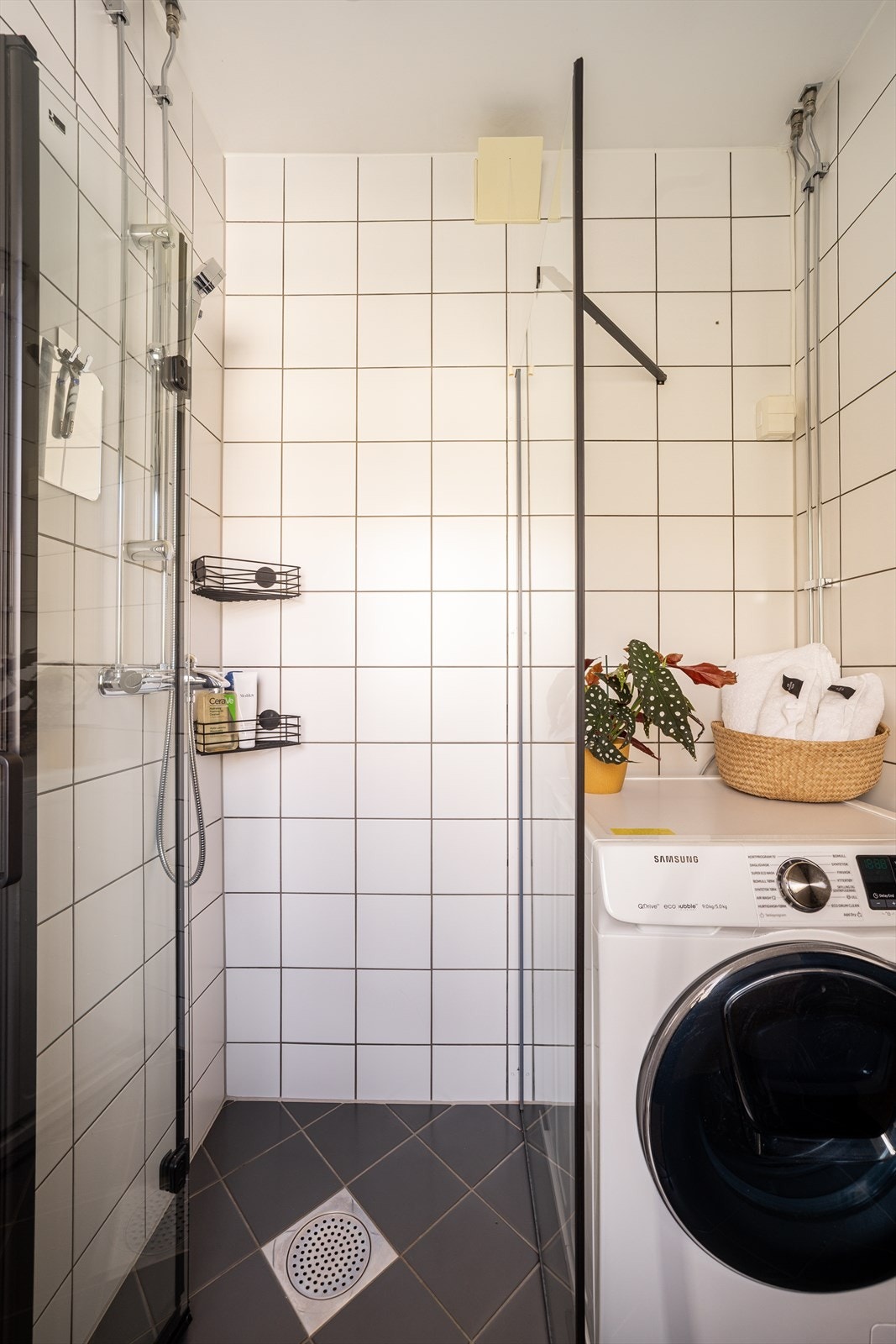 Dusjhjørnet har plassbesparende, innfellbare glassdører som frigjør gulvplass når dusjen ikke er i bruk. Galleribilde