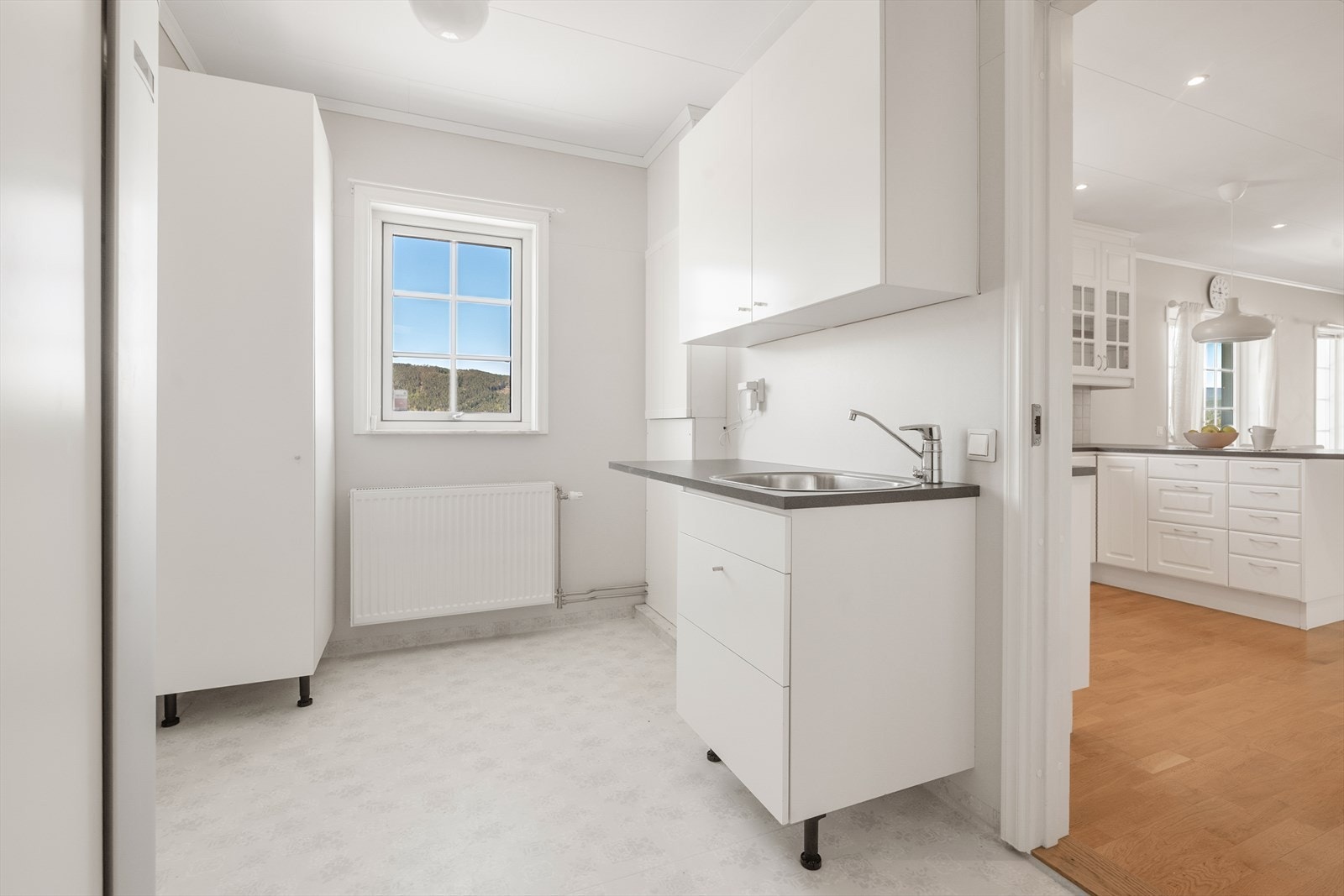Praktisk vaskerom med vinylbelegg, opplegg for vaskemaskin og egen innredning med servant. Galleribilde