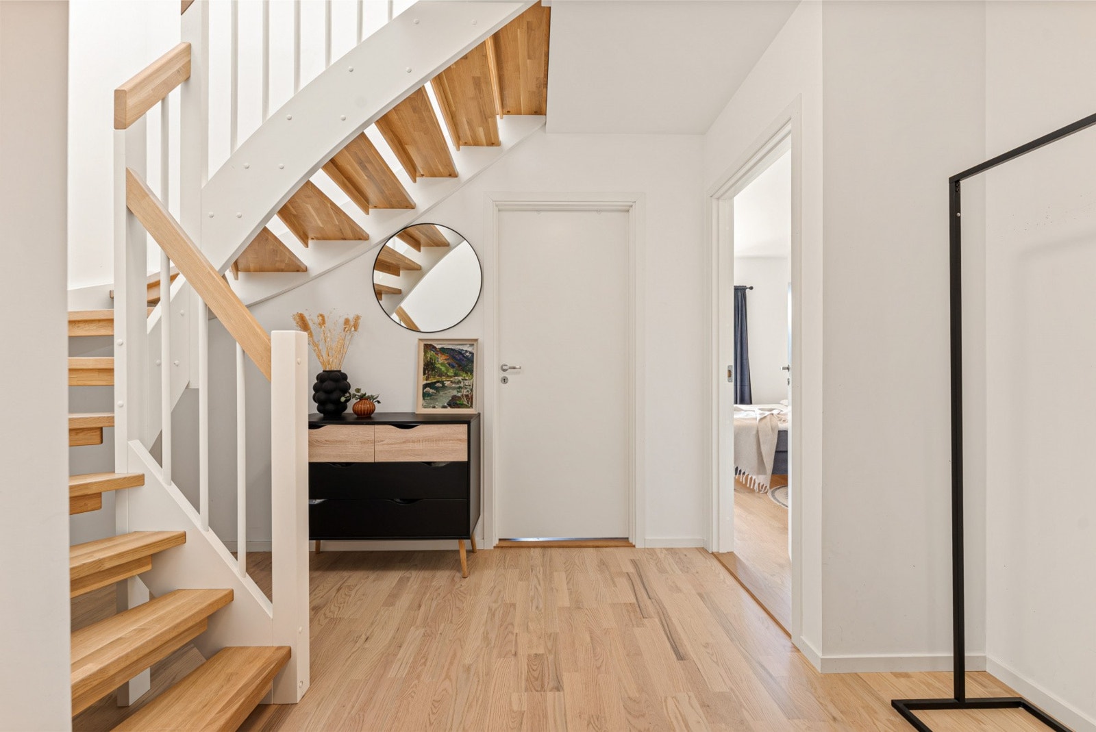 Her møter du en romslig hall med en elegant, lakkert tretrapp som binder de to etasjene sammen på en naturlig måte. Galleribilde