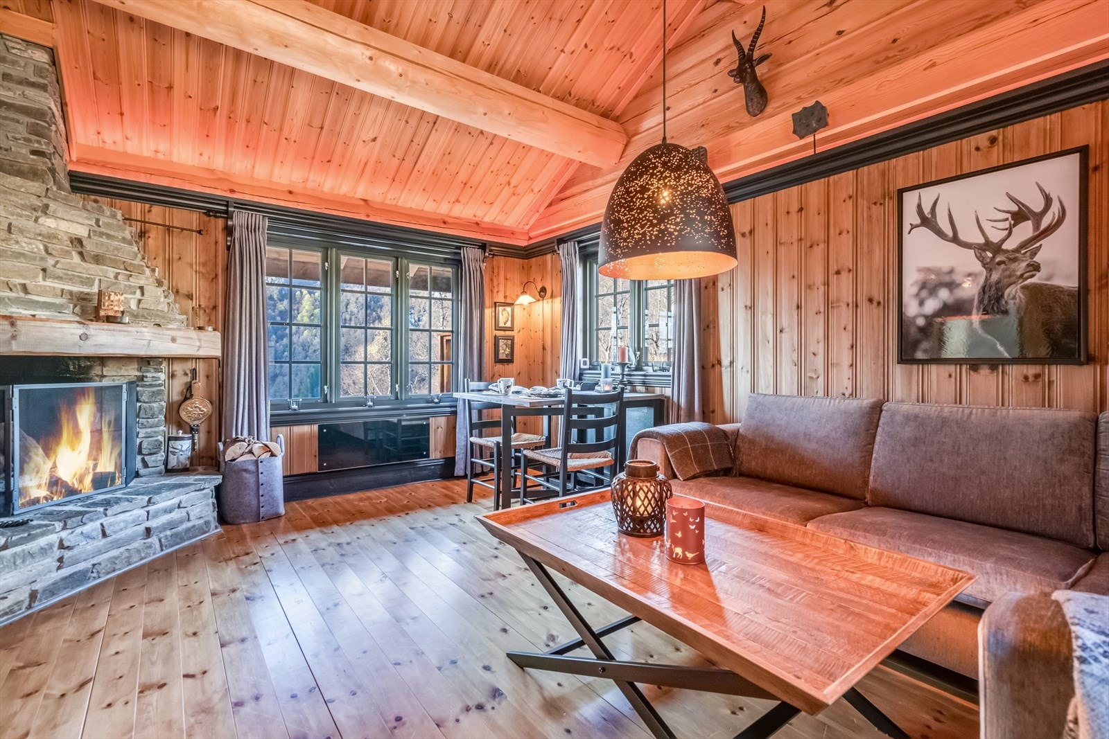 Stuen har plass til både sofagruppe og spisebord, med vinduer som rammer inn naturen utenfor. Galleribilde