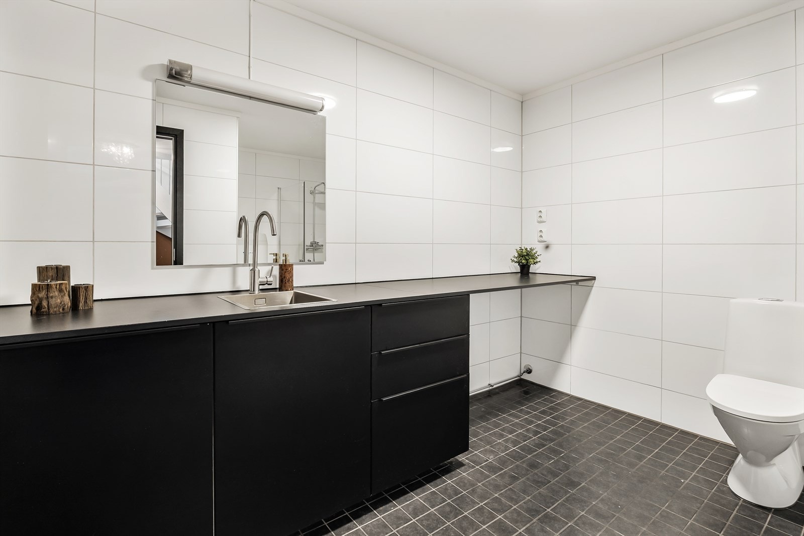 Badet i første etasje er innredet med servant, speil, gulvstående toalett, dusjsone og opplegg for vaskemaskin. Galleribilde