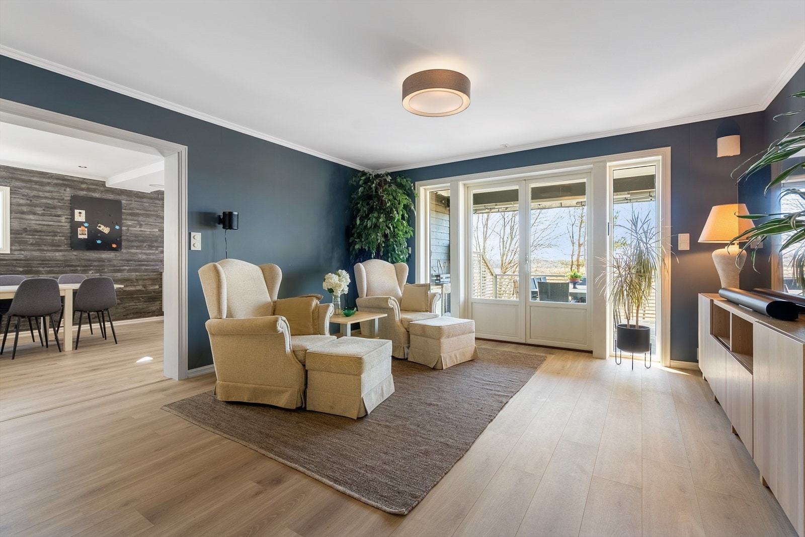 Stilren og innbydende stue i 1.etasje med 1-stavs laminat på gulv og slette overflater i en av boligens stuer. Galleribilde