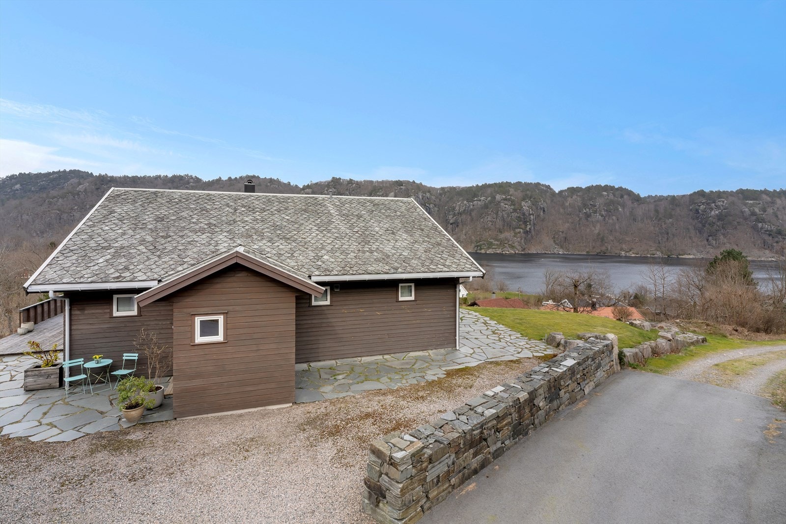 Tomten er pent opparbeidet med gruset innkjørsel og forstøtningsmurer av naturstein. Galleribilde