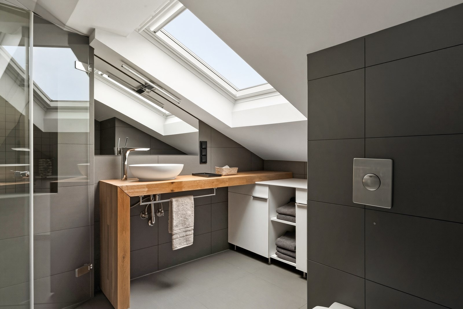 Badet er lekkert flislagt og fremstår svært moderne, med stilrene detaljer og delikat utførelse. Galleribilde