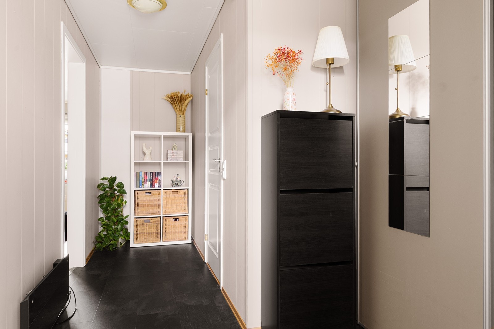 Leiligheten har en romslig og praktisk utformet entré, som er innredet med laminatflis på gulvene, og malte vegger. Fra entréen er det adkomst til badet. Galleribilde