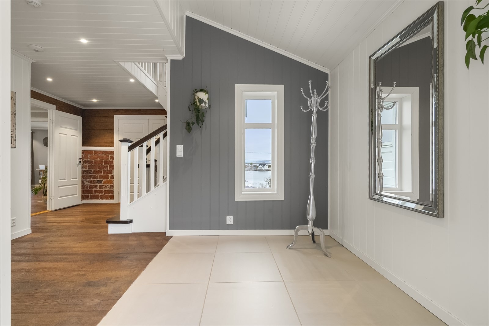 Frå gangen ser ein inn mot stova og trappa som leier opp til andre etasje. Galleribilde