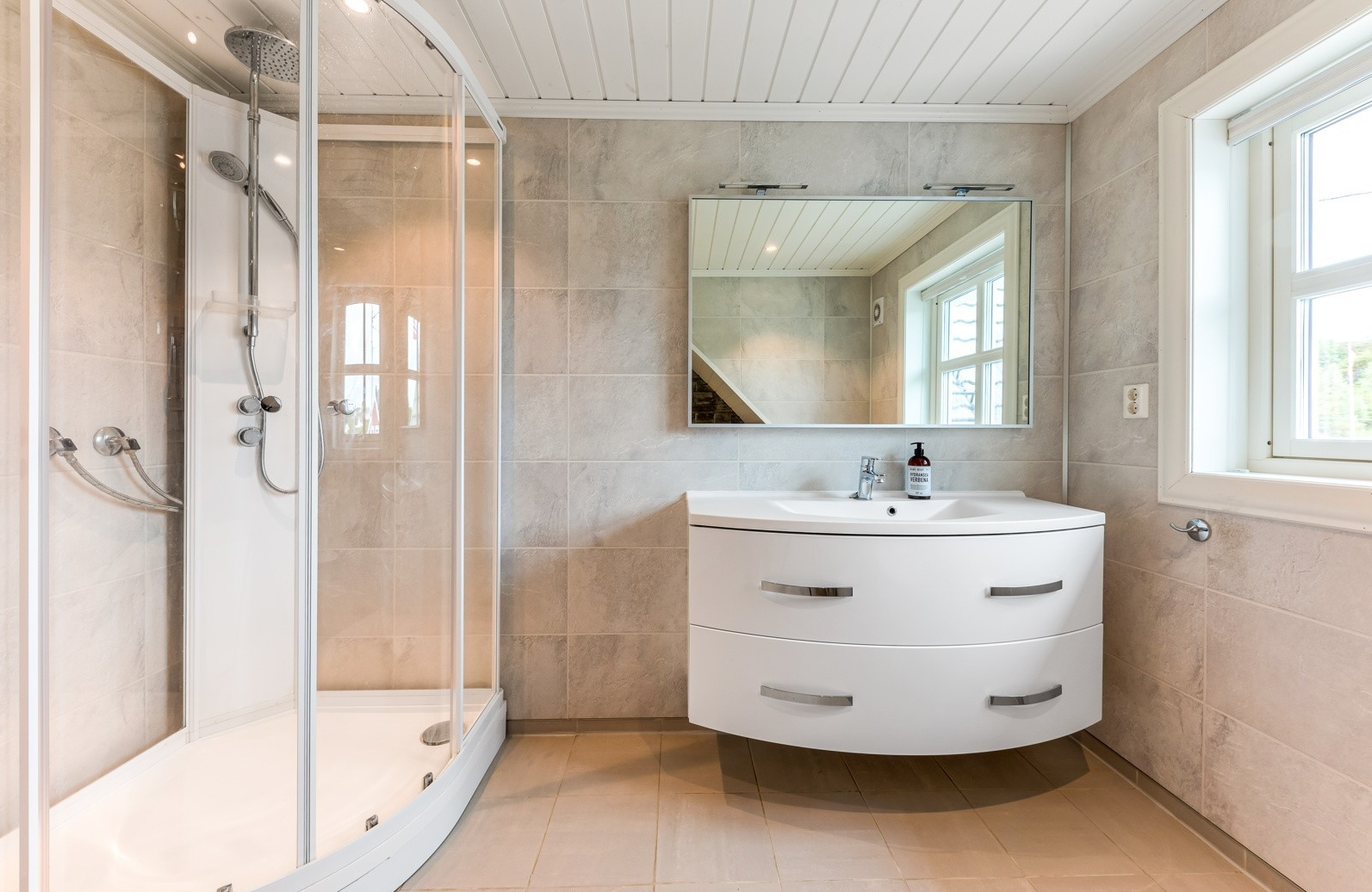 Badet er innreda med dusjkabinett og badekar Galleribilde