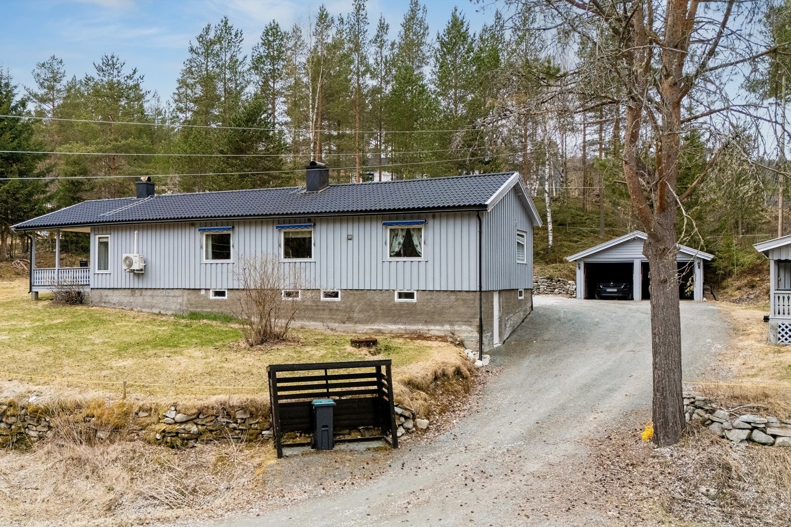 Eiendommen har en romslig, gruset gårdsplass, dobbelgarasje med innlagt strøm og et separat uthus med boder. Galleribilde