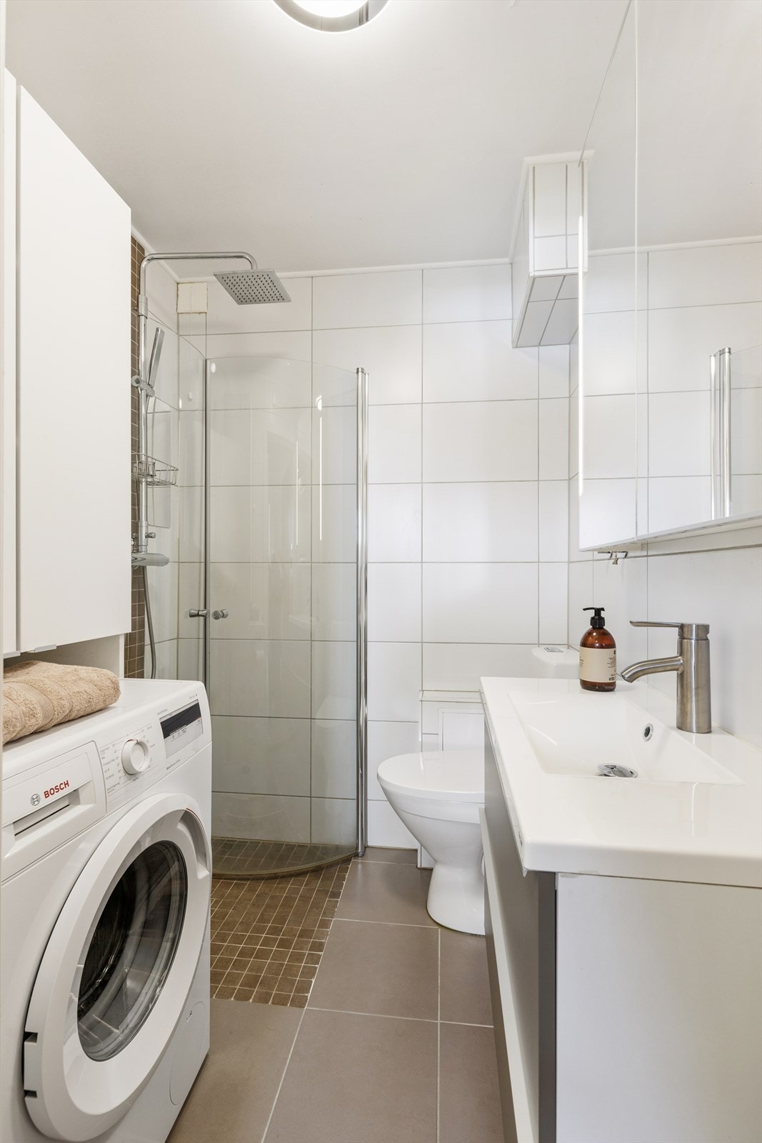 Badet ble oppgradert rundt 2016/17 og har flislagte overflater og en moderne baderomsinnredning med servant. Badet er utstyrt med dusjnisje og gulvstående toalett, samt opplegg for vaskemaskin. Elektriske varmekabler i gulvet gir god komfort. Galleribilde