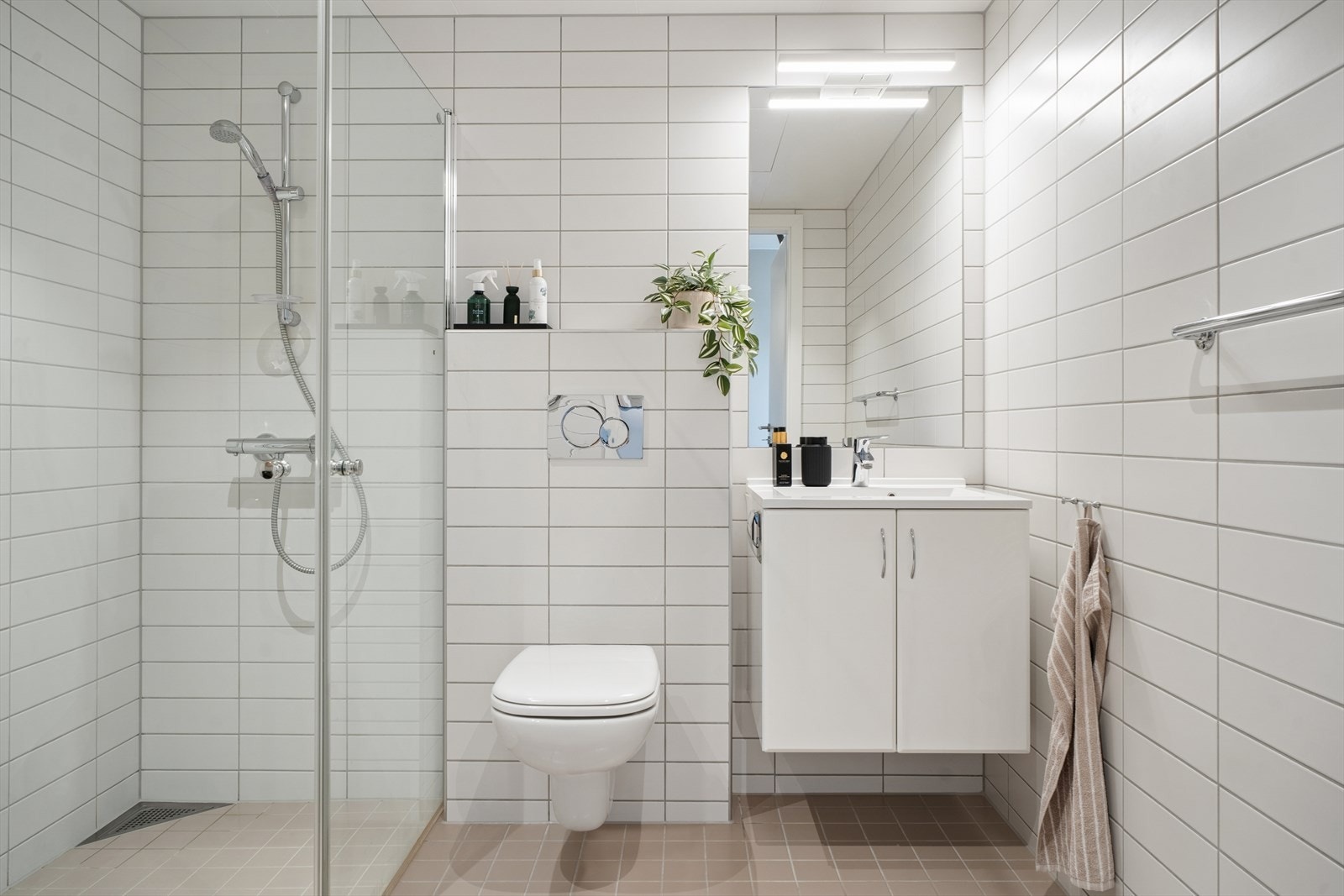 Badet er en prefabrikkert modul fra byggeåret med flislagt gulv med elektrisk gulvvarme for økt komfort og fliser på veggene. Galleribilde