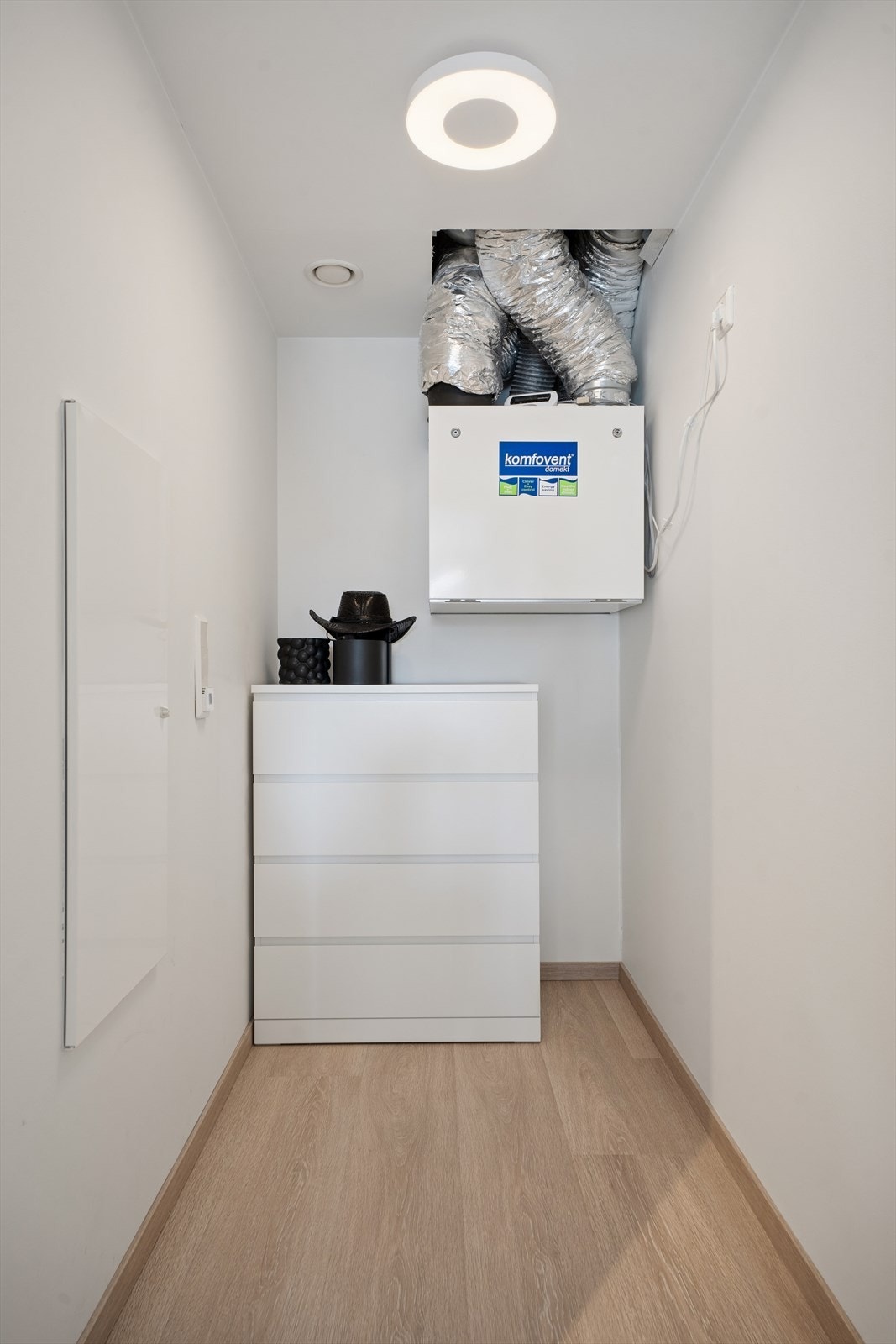 Leiligheten har balansert ventilasjon med varmegjenvinning, som sikrer et sunt inneklima og energieffektivitet, plassert praktisk i boden. Galleribilde
