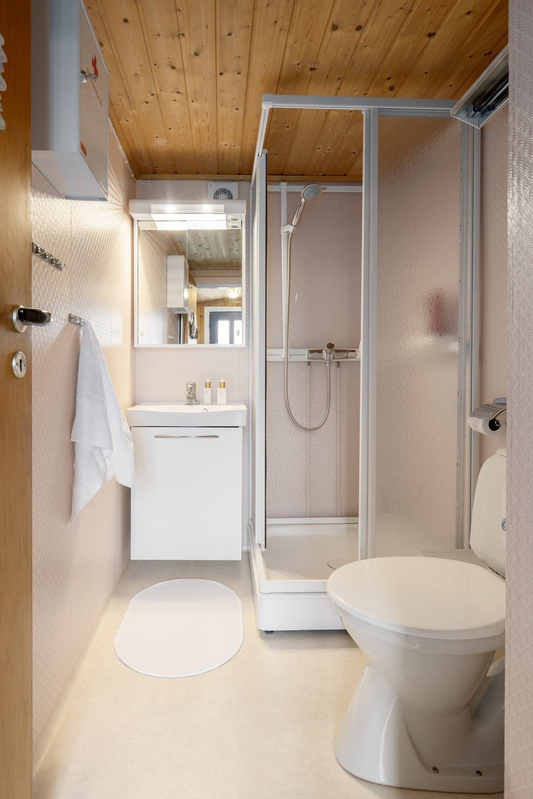 Badet er utstyrt med dusjkabinett, servant med underskap og golvmontert klosett. Oppvarming med veggmontert stråleomn. Galleribilde