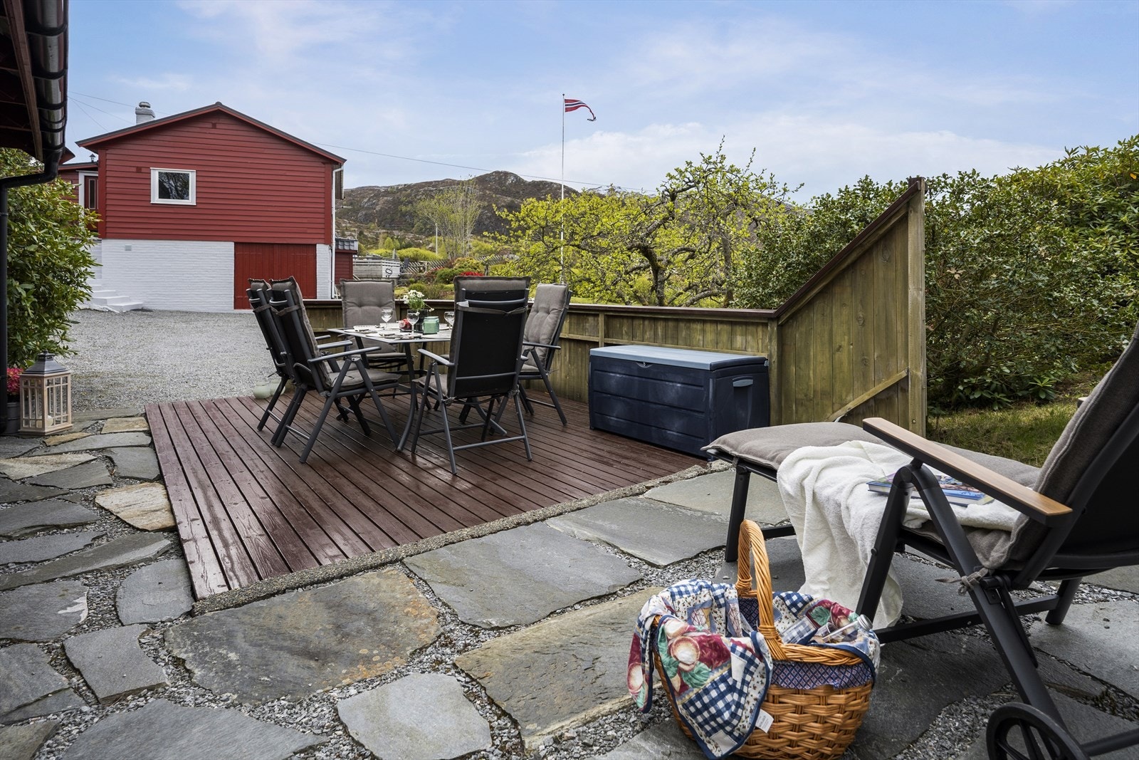 Ein annan av eigedommens uteplassar, med nærleik til hagen. Ser du den tofløya døra i bakgrunnen der? Galleribilde