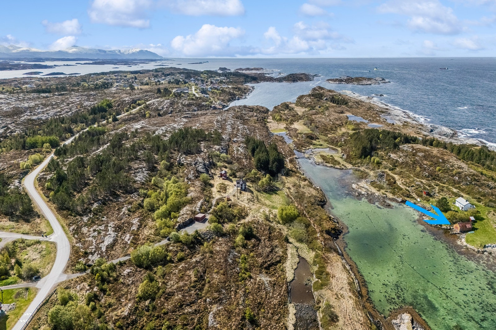 På eiendommen er det i tillegg til boligen oppført garasje, uthus, naust, fjøs og sommerfjøs. Naust markert med blå pil Galleribilde