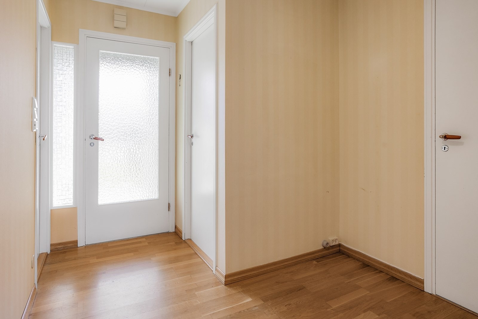 Fra vindfanget kommer du inn i en gang med parkettgulv som leder videre til boligens øvrige rom. Galleribilde