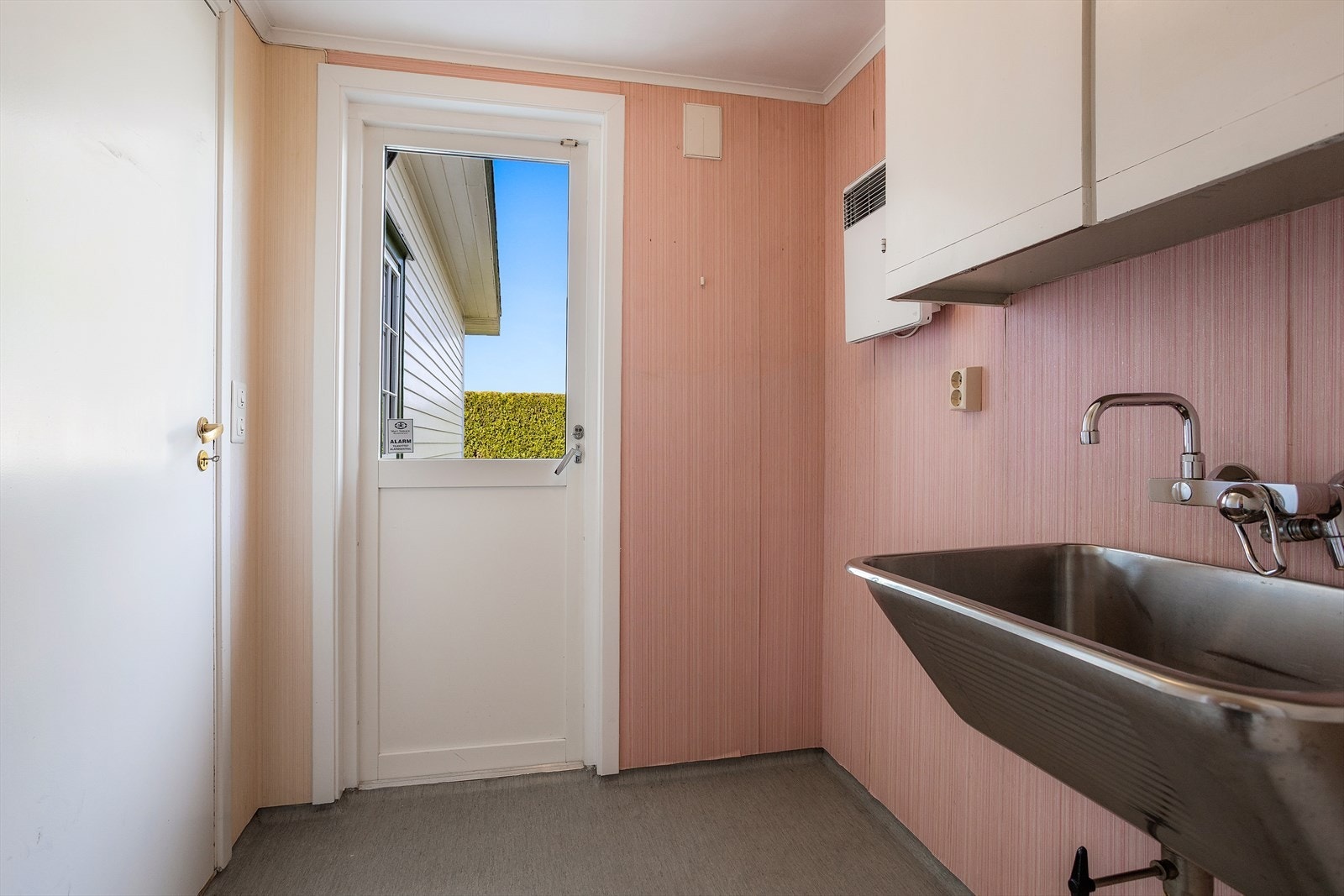 Praktisk vaskerom med skyllekum i stål, opplegg for vaskemaskin og egen utgang. Galleribilde