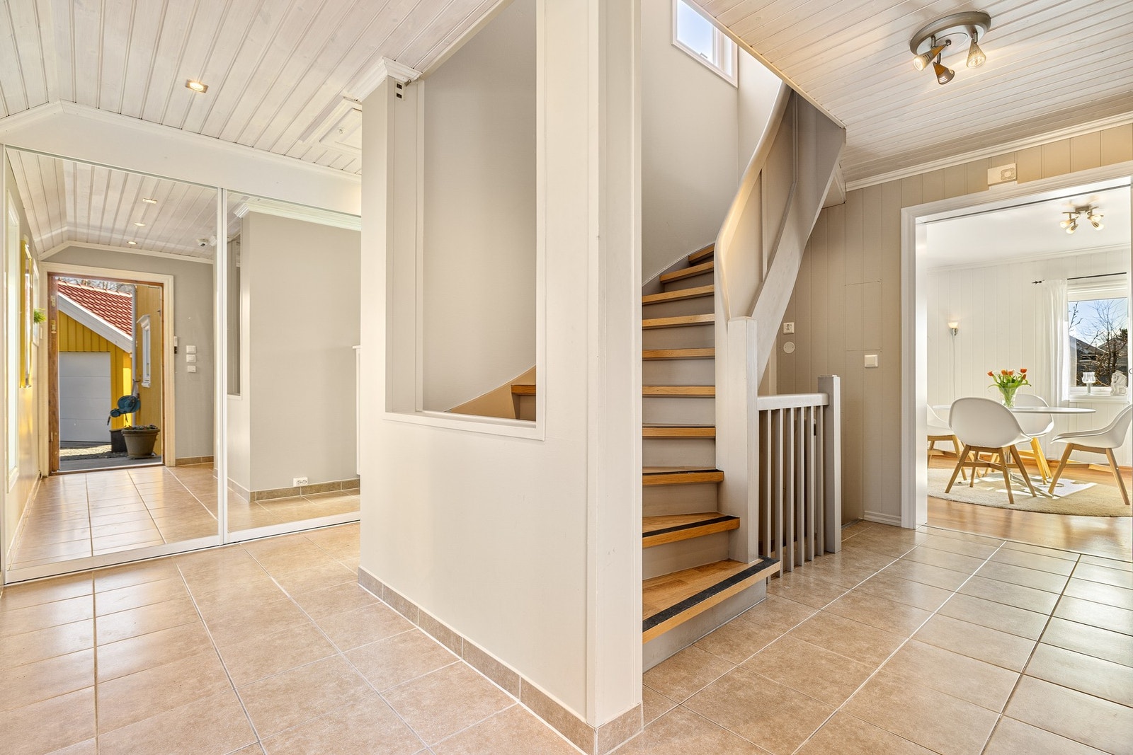 Hallen er romslig med flislagt gulv og god plass til oppbevaring av sko og yttertøy i en meget stor skyvedørsgarderobe. Galleribilde