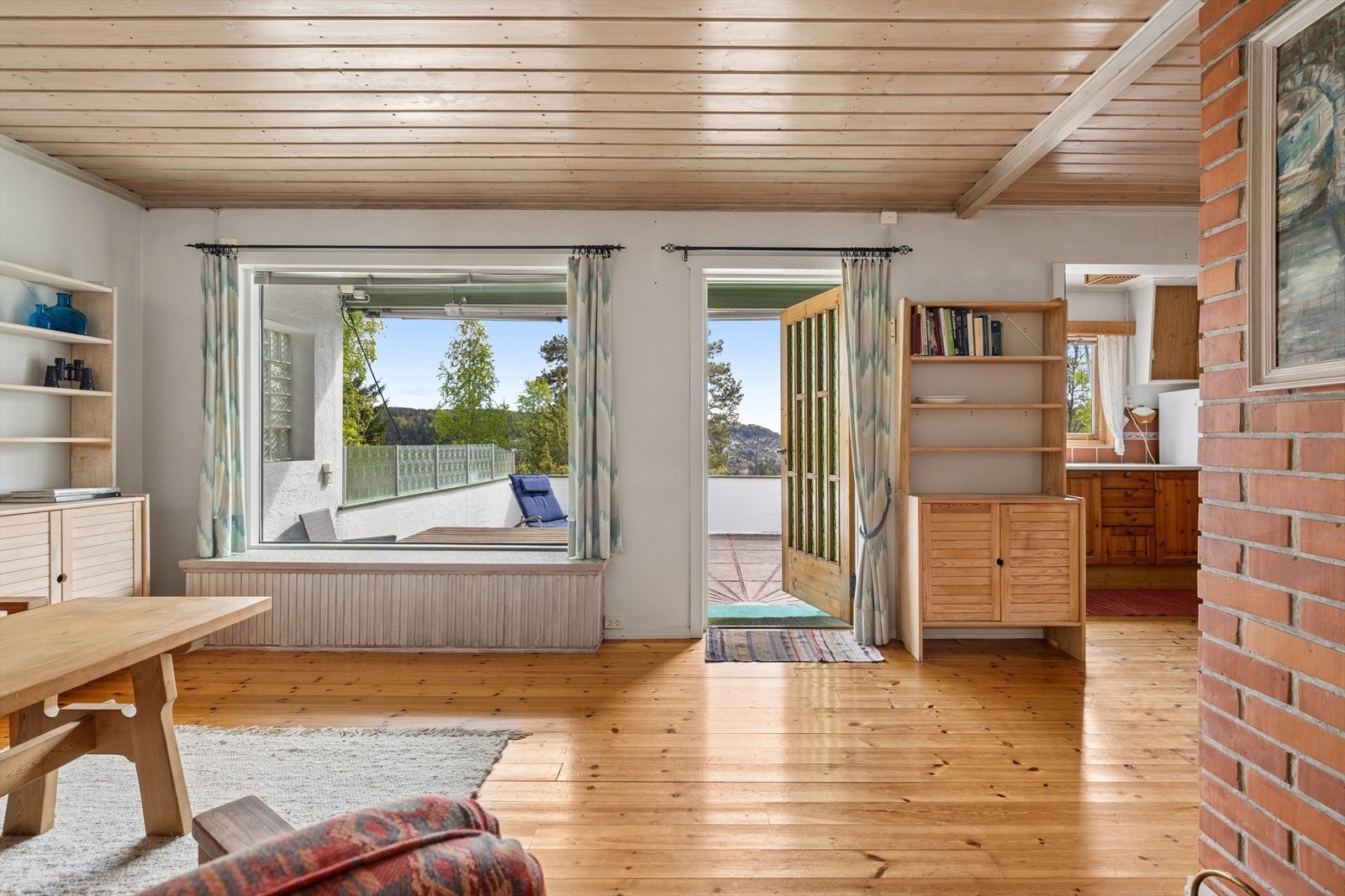 Store vindusflater slipper inn rikelig med naturlig lys og gir rommet en lys og luftig atmosfære. Galleribilde