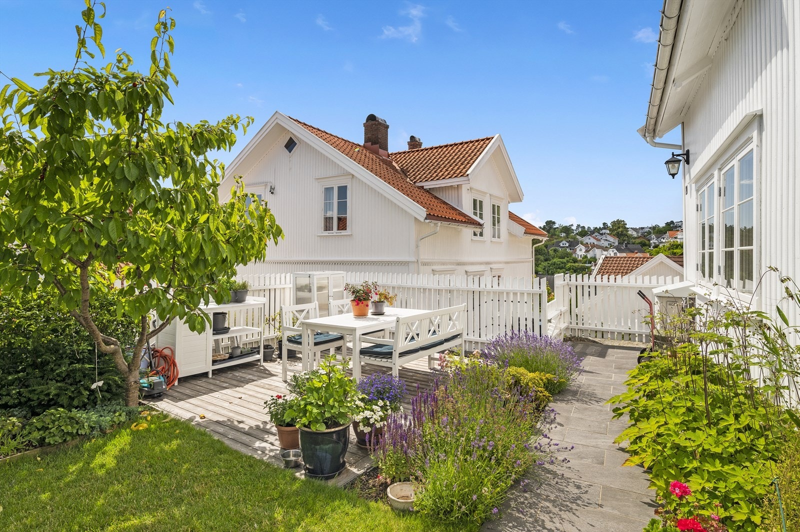 Beplantet med blomster/busker, hekk, plen og frukttrær. Galleribilde