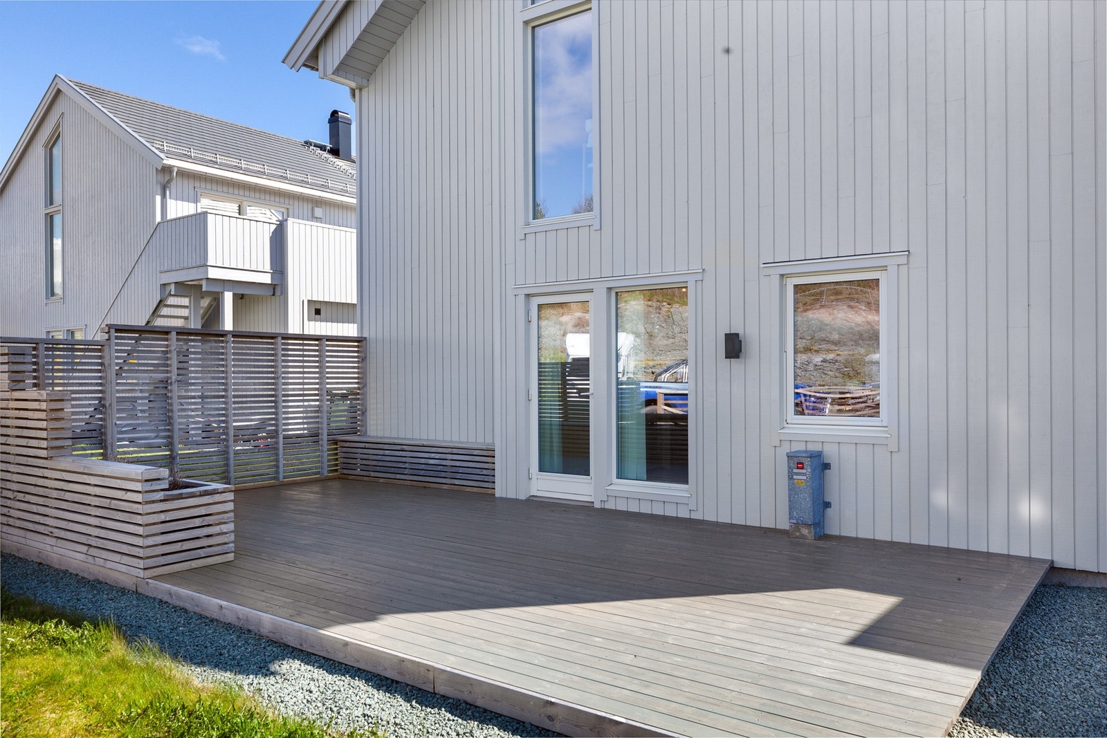 Platting på bakkeplan med spilevegg og plassbygde sitteplasser Galleribilde