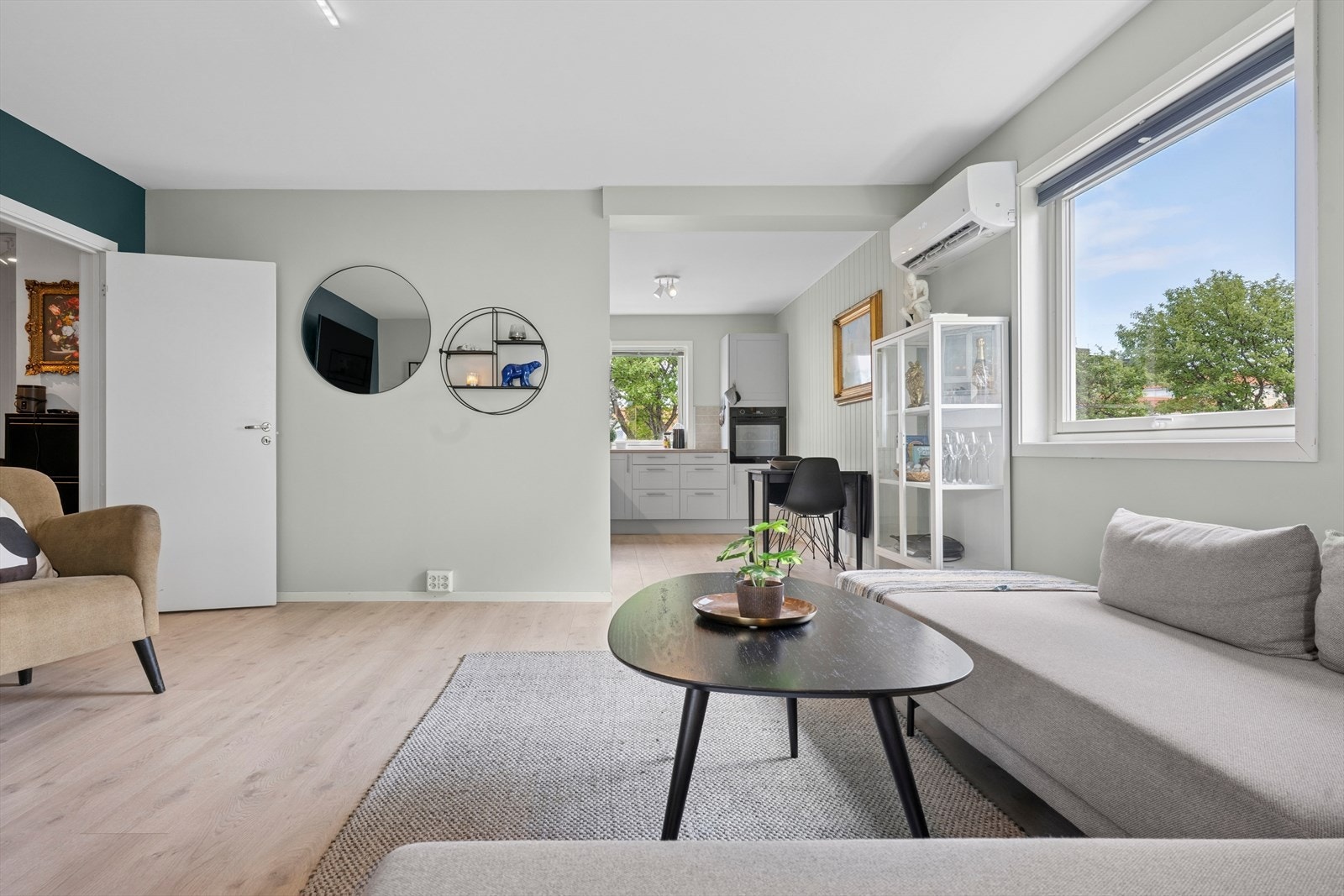 Leilighetens oppholdsrom har en åpen løsning som kombinerer stue og kjøkken på en funksjonell måte. Stue har laminatgulv og malte vegger. Galleribilde