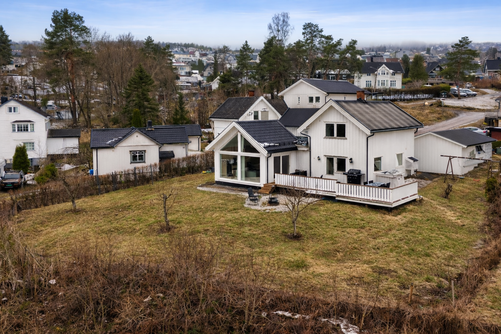Eiendommen har en stor og skjermet tomt på totalt 899 kvm opparbeidet med terrasse, gressplen og diverse beplantning. Bildet er redigert. Galleribilde