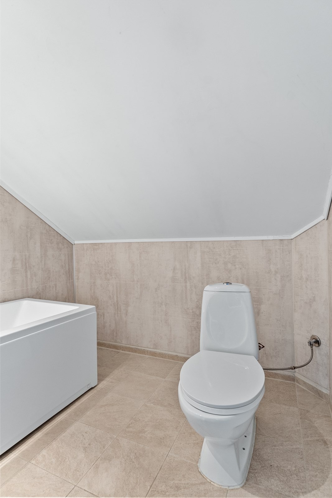 På badet er det gulvmontert wc, vaskeservant i innredning og badekar. Galleribilde