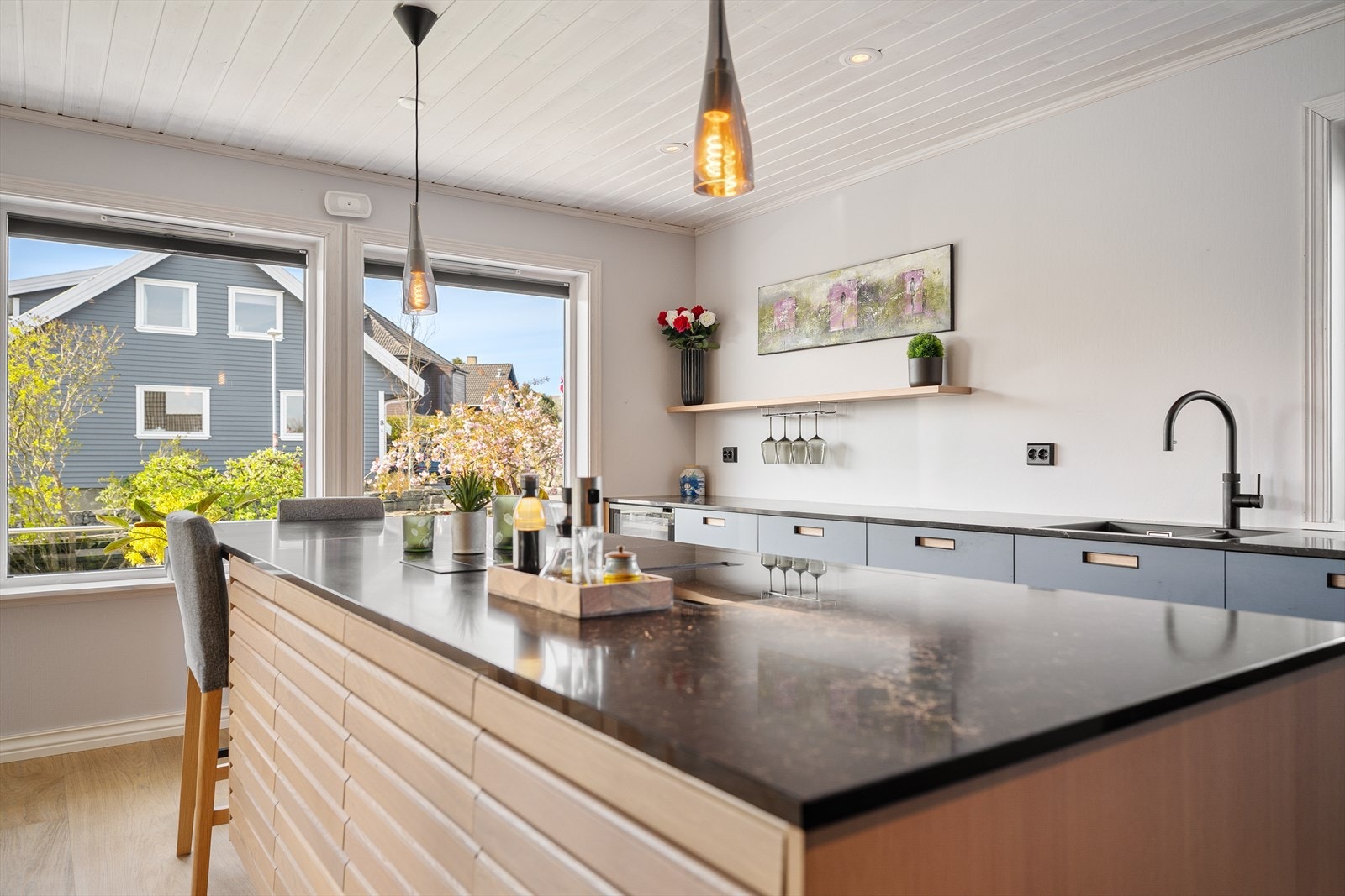 Her får man et lekkert, velutstyrt og toppmoderne kjøkken, der en funksjonell L-form med praktiske høyskap suppleres av en flott kjøkkenøy med egen barløsning. Galleribilde