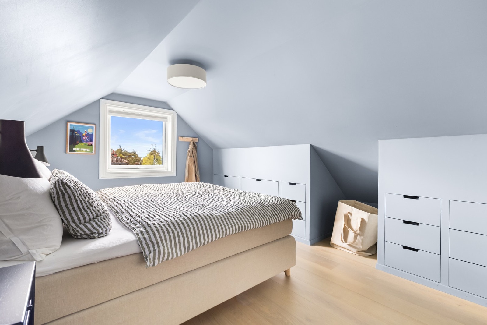 Lyst og luftig hovedsoverom med plassbygde garderober langs veggen. Galleribilde
