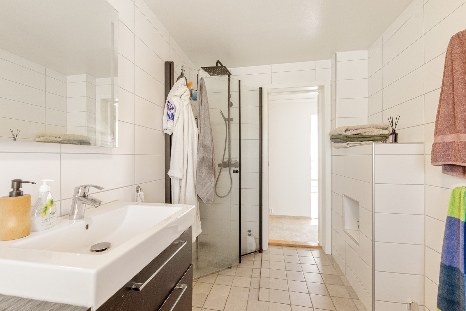 Opplegg for vaskemaskin, servantskap med hvit servant og blandebatteri fra Grohe, fordelerskap med stoppekran. Rommet har mekanisk avtrekk Galleribilde