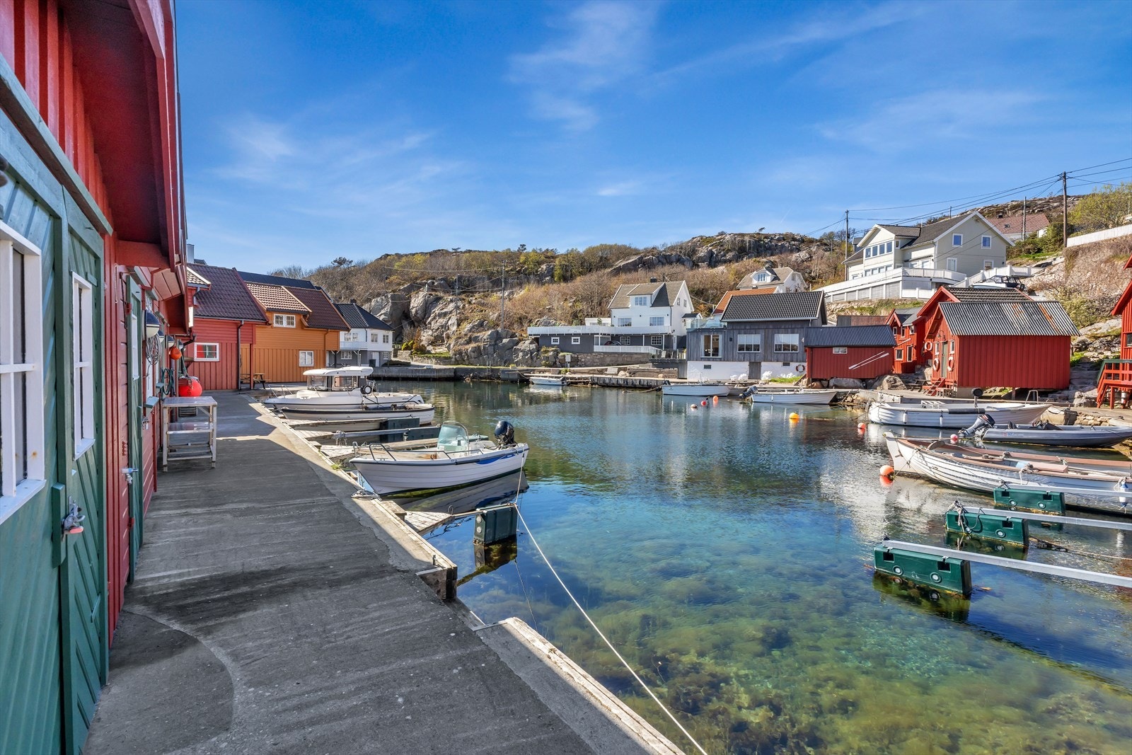 Havnemiljøet preges av hvite trehus og klassiske, røde sjøbuer. Galleribilde