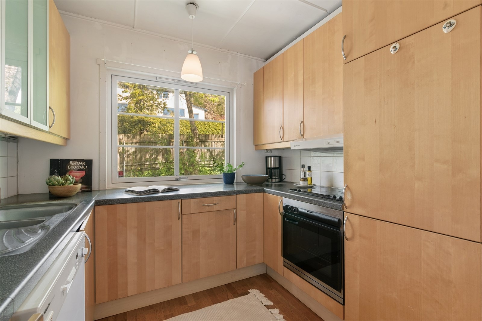 Kjøkkenet ligger adskilt i eget rom med en innredning bestående av slette finerte bøkfronter og benkeplate i laminat. Galleribilde