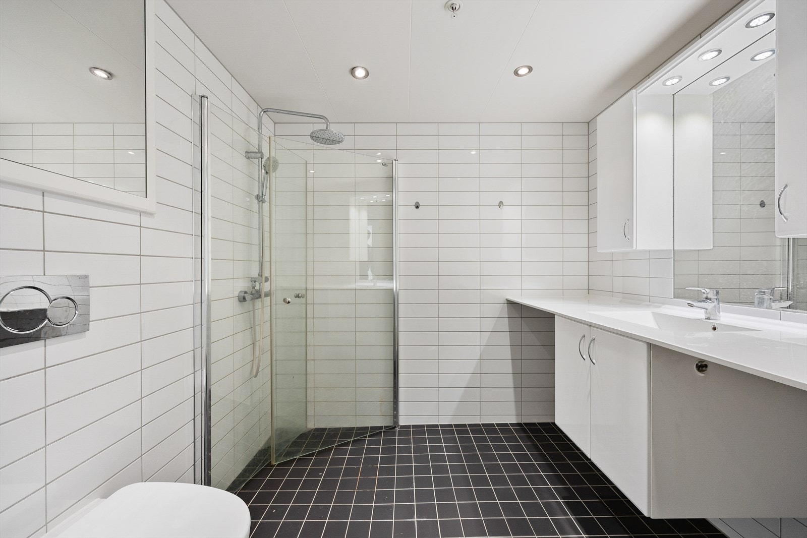 Badet er utstyrt med vegghengt toalett, dusjhjørne og opplegg for vaskemaskin. Galleribilde