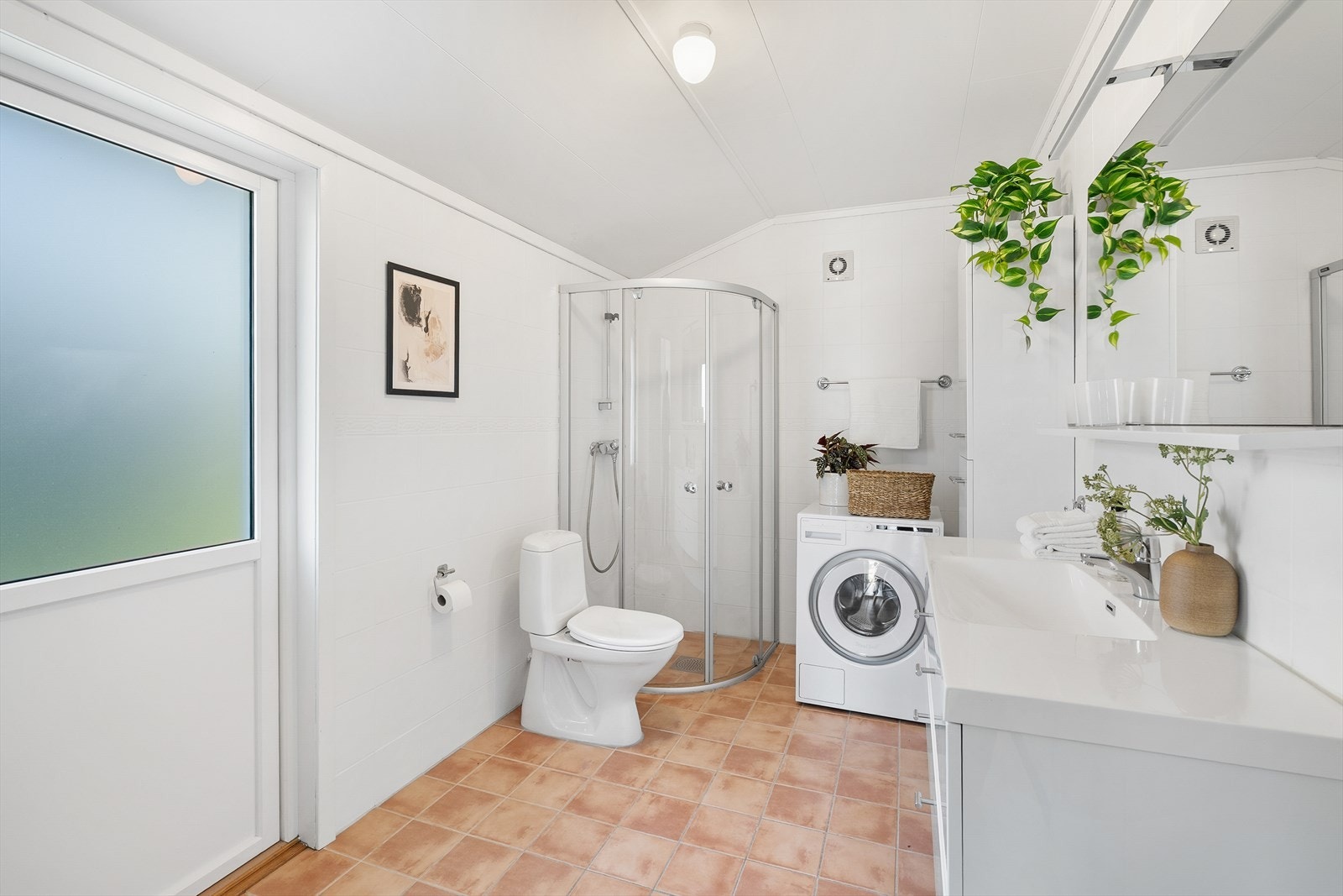 Romslig, flislagt bad i 1. etasje med adkomst fra kjøkkenet, og med dør ut til terrassen på baksiden av huset. Galleribilde