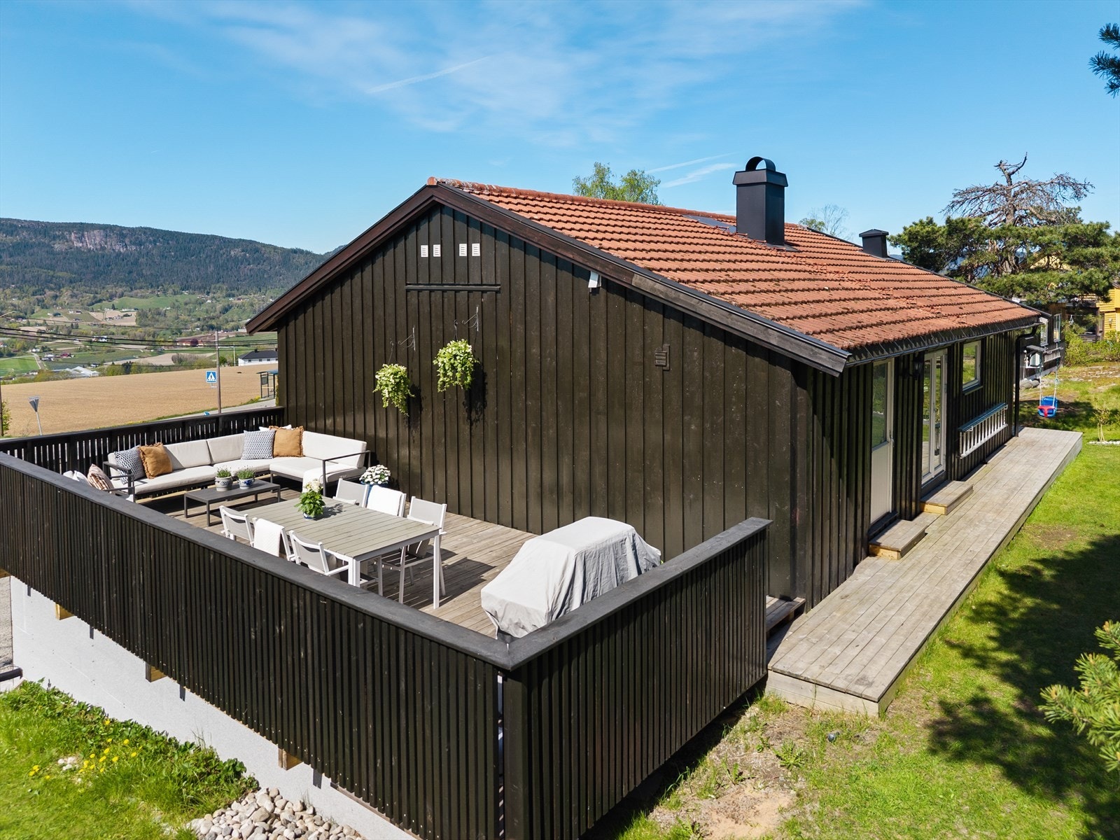 Eiendommen har en sydvestvendt terrasse på ca. 45 kvm (ny i 2025) med svært gode solforhold og flott utsikt mot Lierdalen. Galleribilde
