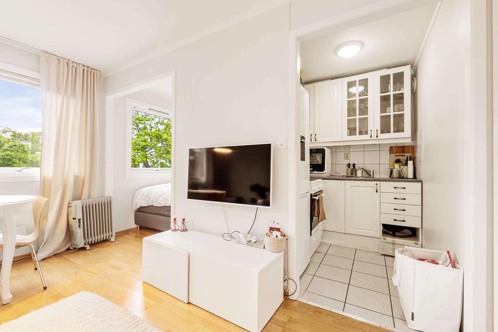 Eldre kjøkken med profilerte fronter og fronter med treramme og glass. Laminert benkeplate med oppvaskkum i rustfritt stål med svingbart blandebatteri fra Oras. Galleribilde
