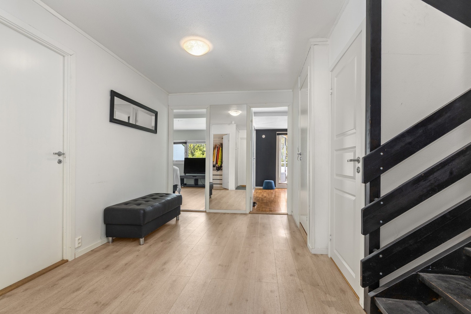 Den romslige hallen i 1. etasje har trapperom, lyse veggflater og linoleumsdekke på gulv Galleribilde