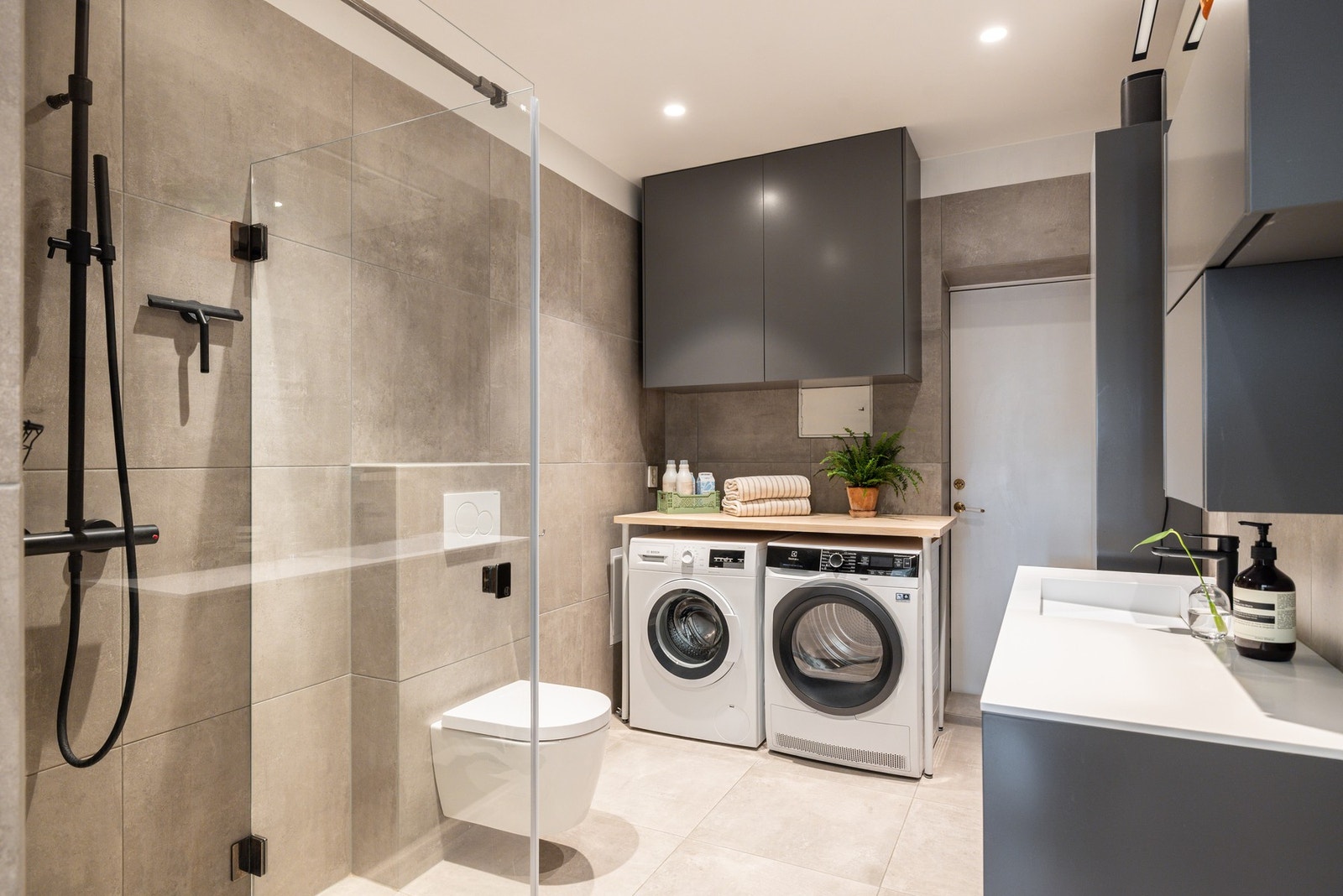 Badet har en egen nisje med plass vaskemaskn og tørketrommel og har rikelig med lagringsplass i flere skap. Galleribilde