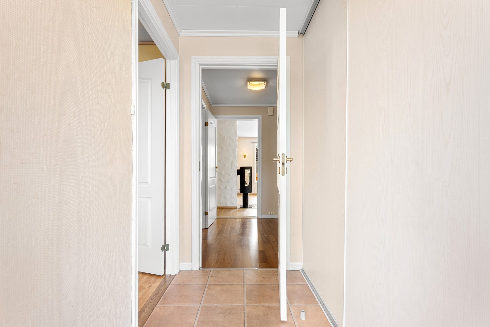 Flislagt entré med praktisk skyvedørsgarderobe og god plass til oppbevaring av yttertøy og sko. Galleribilde