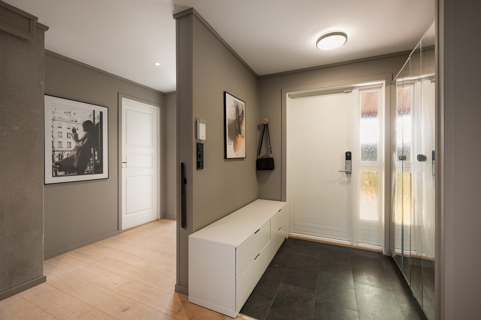Entréen er utstyrt med flislagt gulv og garderobe med speilfronter. Galleribilde