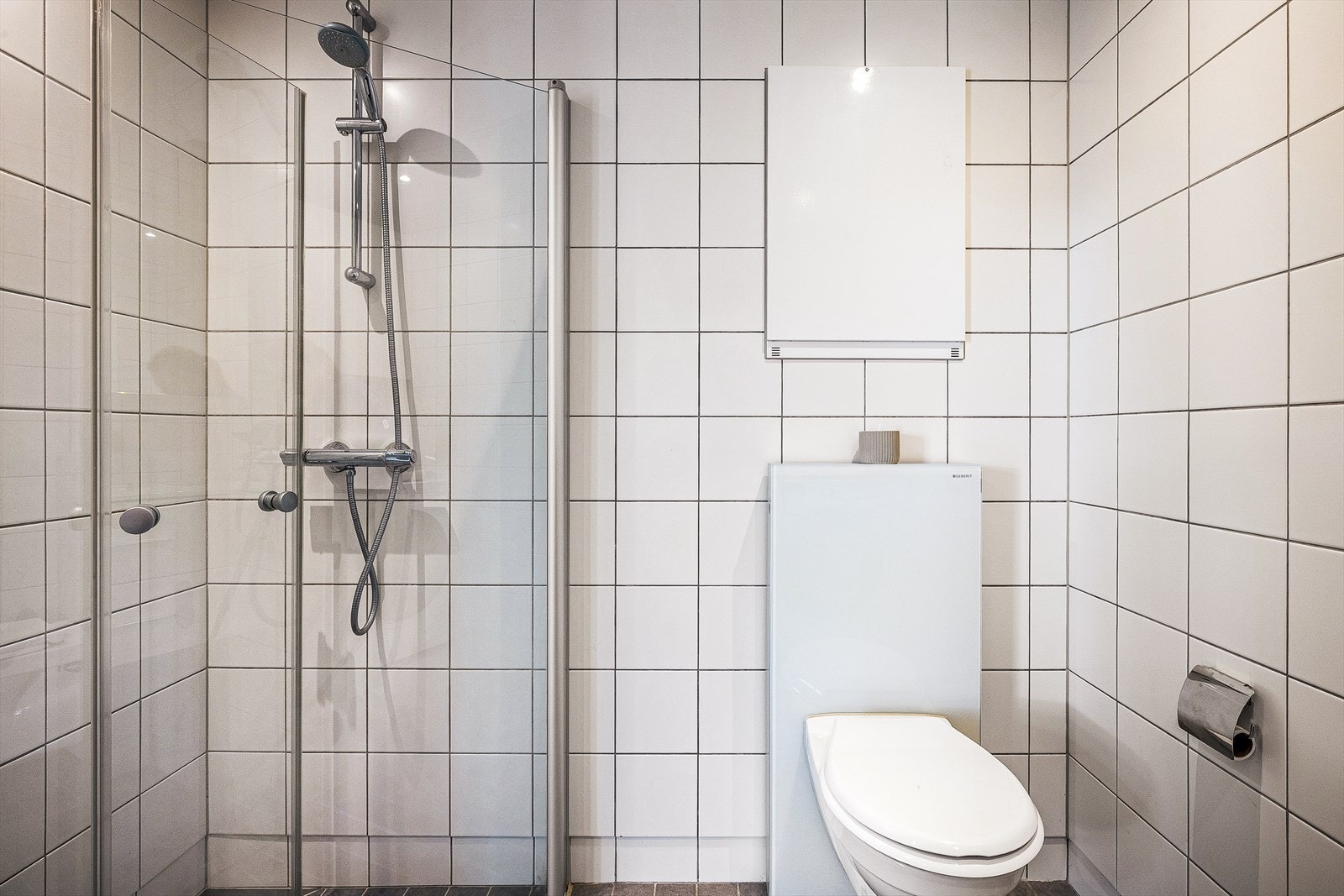 Leilighetens baderom er delikat helfliset med varme i gulvet. Galleribilde