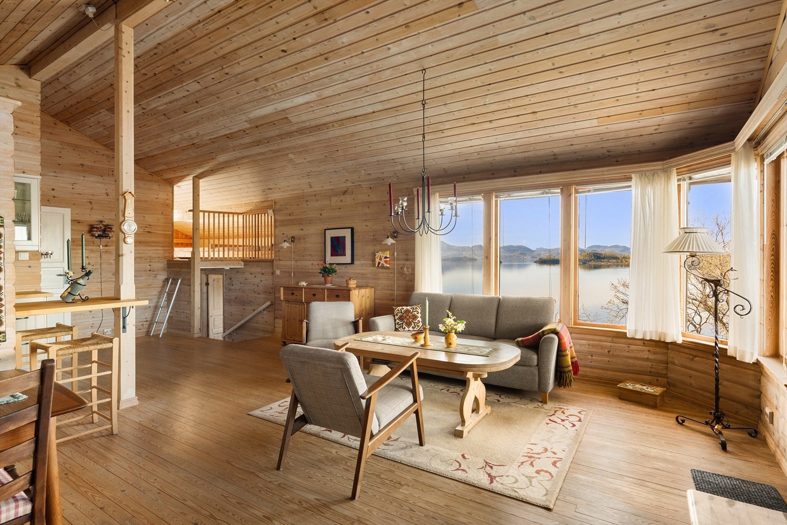 Store vindusflater i stuen gir rikelig med dagslys og flott utsikt mot sjøen. Galleribilde
