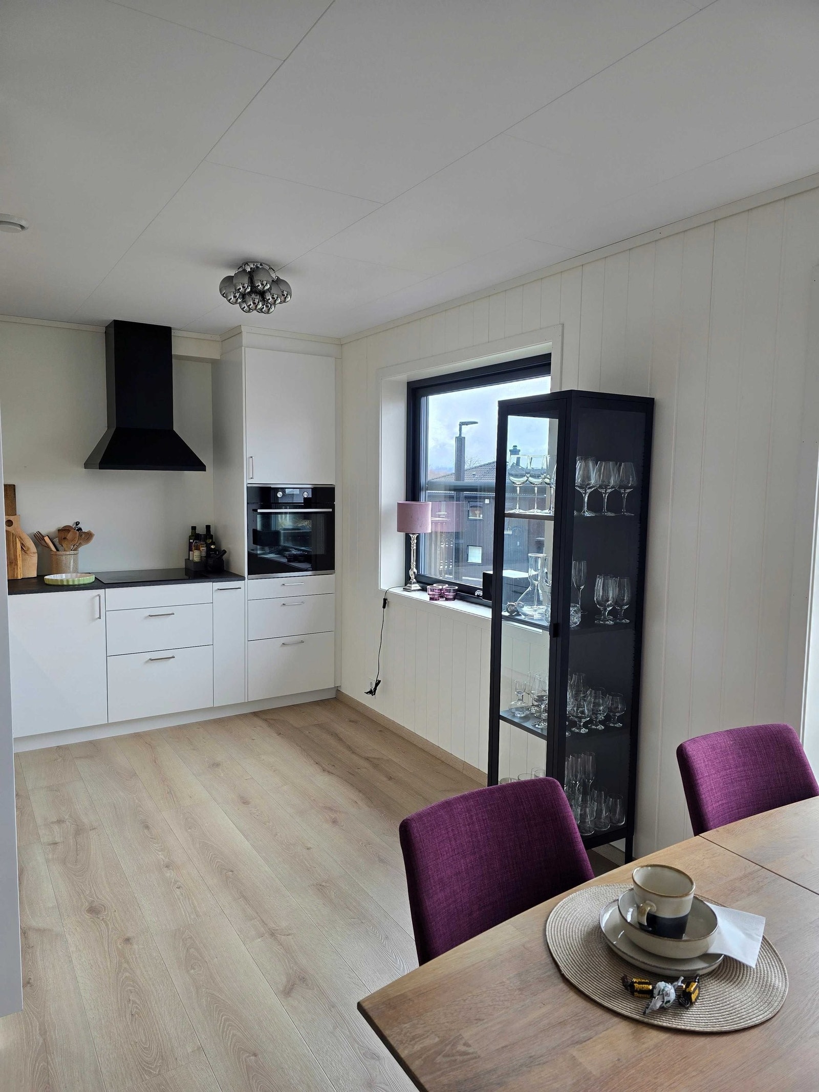 Kjøkkendelen har en pen, takhøy innredning over vask med profilerte fronter og laminert benkeplate. Karusell hjørneskap med god oppbevaring. Galleribilde