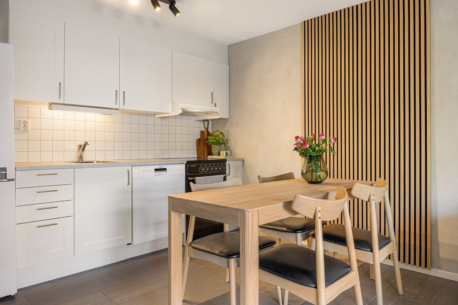 Kjøkkenet har et funksjonelt design. Frontene er hvite og profilerte, mens den laminerte benkeplaten er koksgrå. Galleribilde