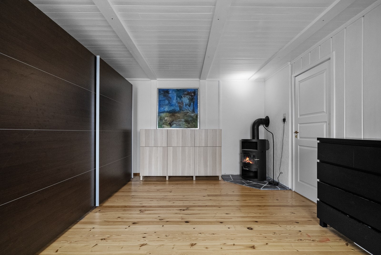 I kjellarstova er det montert ein stor skyvedørsgarderobe, samt vedovn Galleribilde