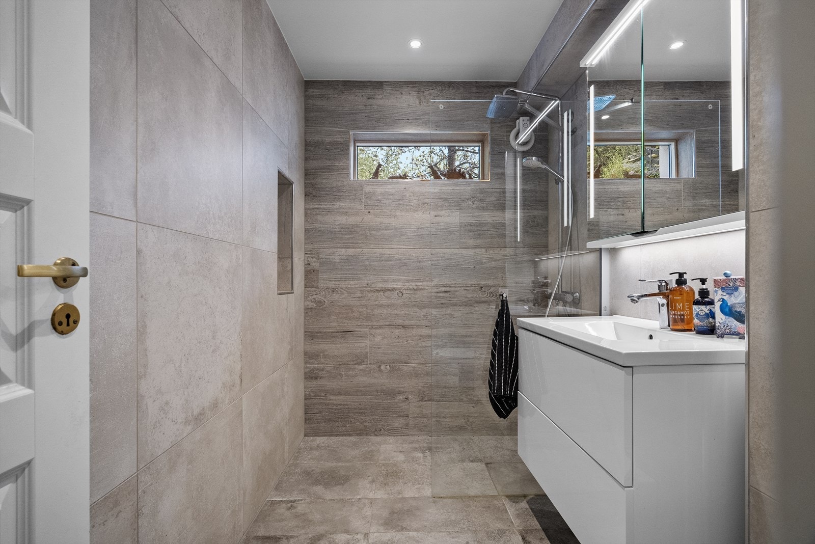 Badet i underetasjen vart oppgradert i 2020 med varmekabel, keramiske fliser og regndusj Galleribilde